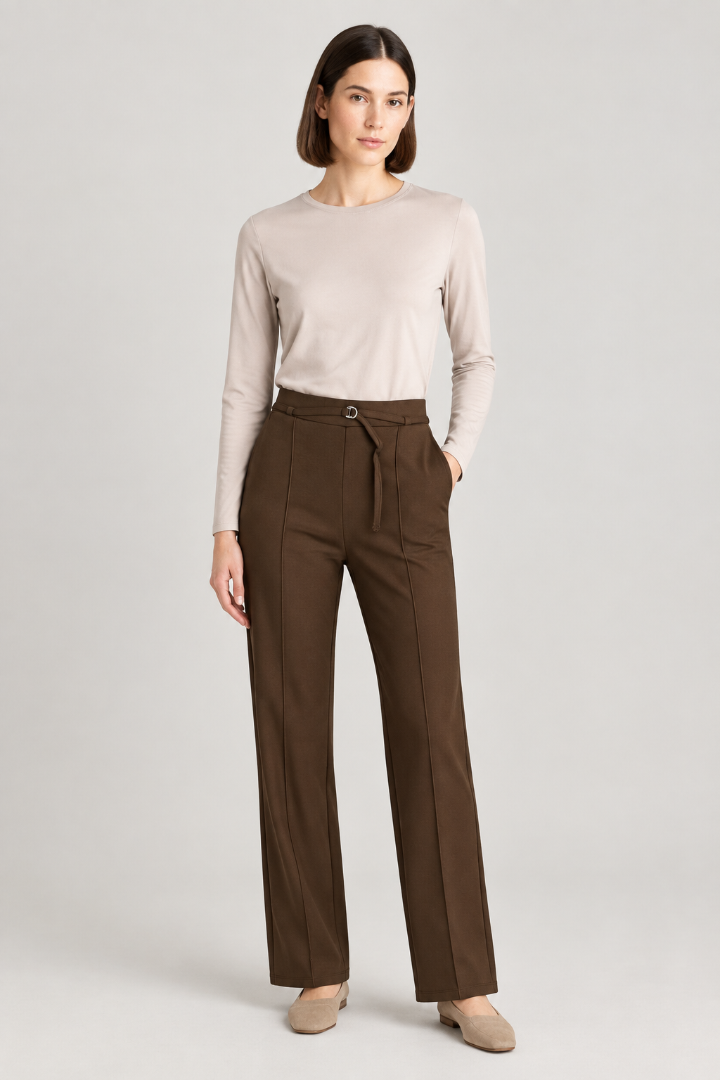 Model wearing chocolate-brown trousers with a beige long-sleeve top | Both sold at GM Boutique, Galway