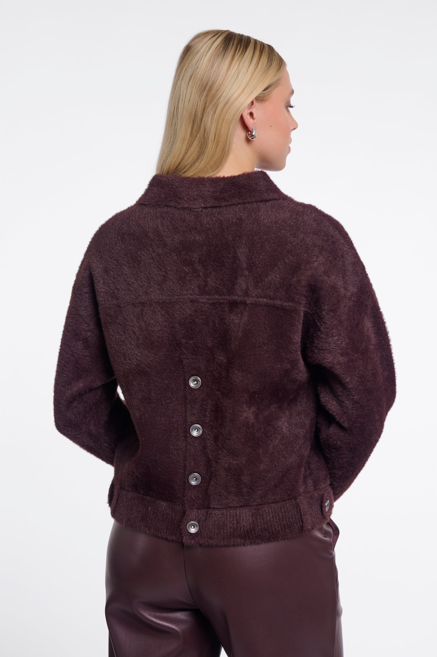 Woman wearing a brown suede jacket on a white background