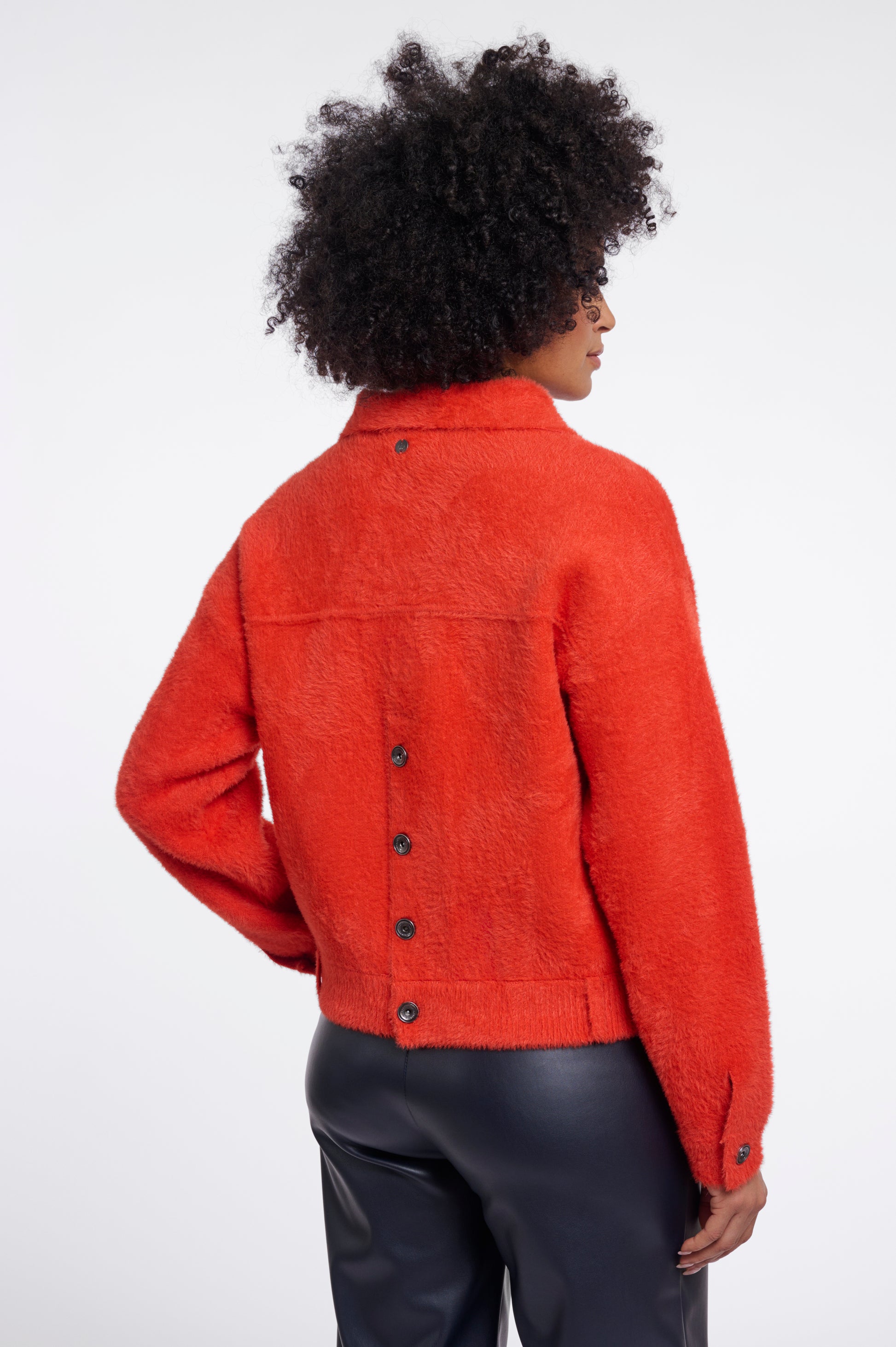 Person wearing an orange jacket on a white background