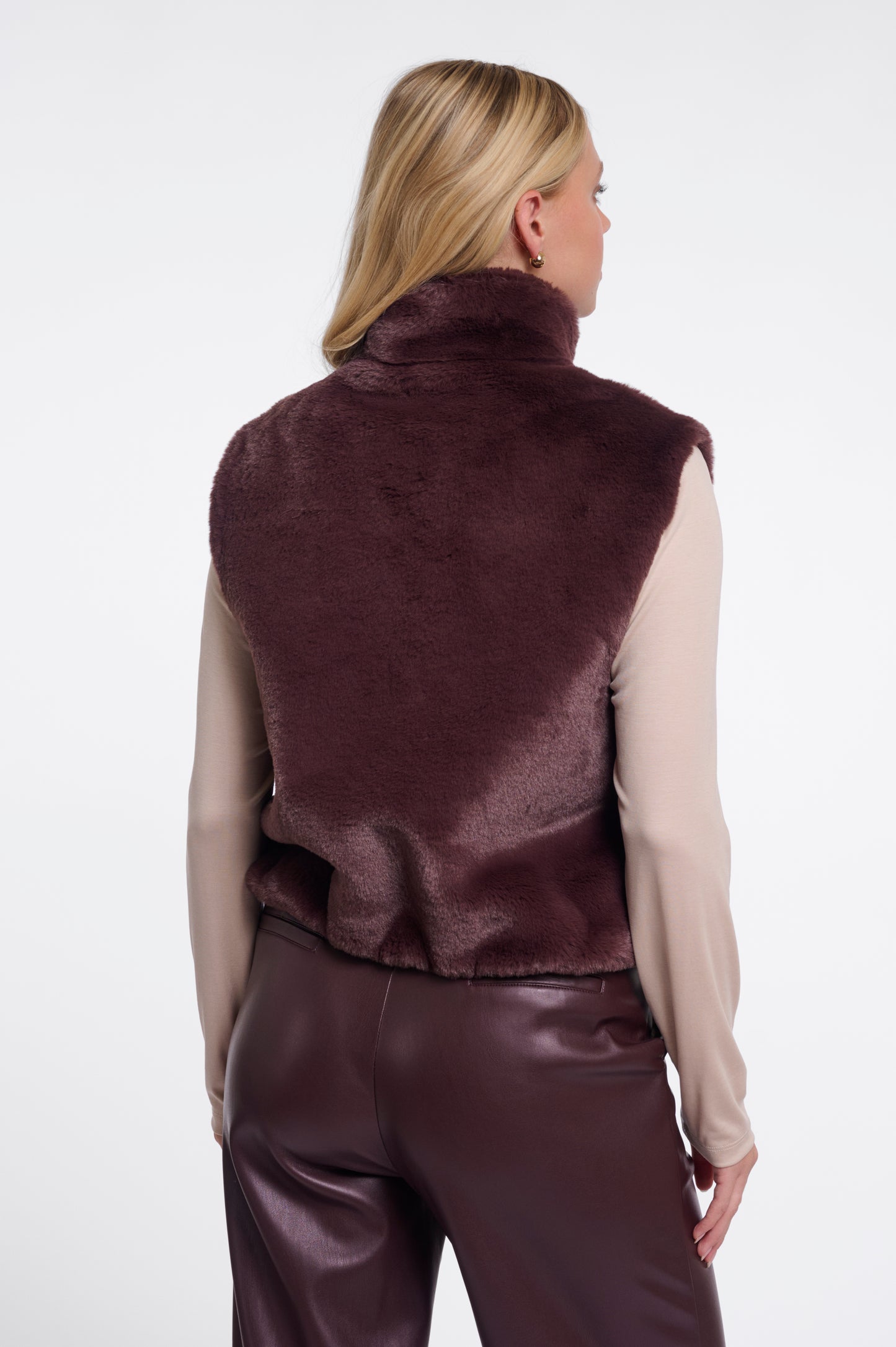 Woman wearing a brown vest and pants on a white background