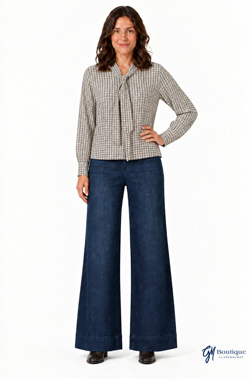 Checked blouse and flat boots with near-floor jean hems