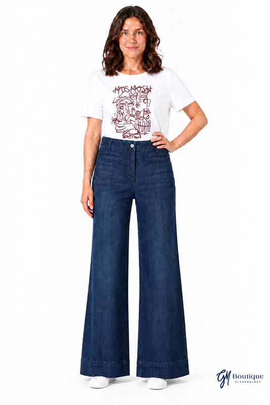 White graphic T-shirt and flat trainers with near-floor jean hems